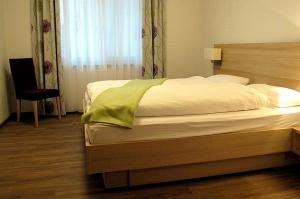 恩茨河畔法伊欣根瓦希科夫公寓的卧室配有床、椅子和窗户。
