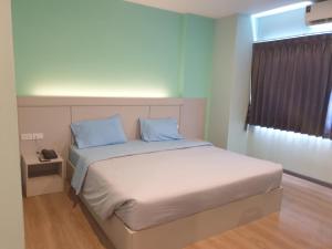 Ban Khlong WaSritrang Residence的一间卧室配有一张带蓝色枕头的床和一扇窗户。