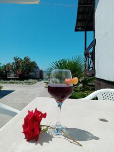 阿拉克哈济Солнечный Берег的一杯葡萄酒和一张红玫瑰放在桌子上