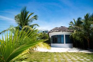 惹岛Ly Son Pearl Island Hotel & Resort的一座白色的小建筑,拥有茅草屋顶