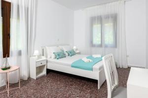 帕纳基雅Whitegold Apartments Panagia的白色的卧室设有床和窗户