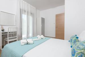 帕纳基雅Whitegold Apartments Panagia的一间卧室配有带毛巾的床