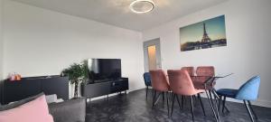 诺伊斯·勒·格兰德Appartement 65m² Paris - DisneyLand - RER A的客厅配有桌椅和电视。