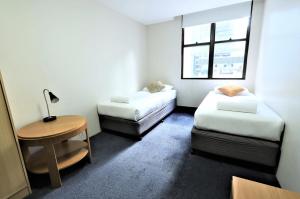 悉尼悉尼小憩酒店的客房设有两张床、一张桌子和一扇窗户。