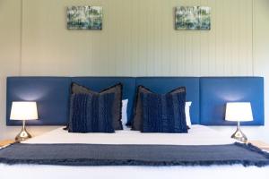 波高尔宾归隐庄园酒店的一张带枕头和两盏灯的蓝色床头床