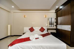 莱卡邦黄金机场套房酒店的卧室配有带红色枕头的大型白色床