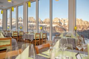 芙露姆赛山Ferienwohnungen Tannenboden的餐厅配有桌椅,位于山脉的背景中