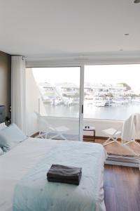 勒格罗-迪鲁瓦Marina NS Guesthouse的卧室配有1张床,享有码头的景致