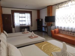 公主港OYO 880 Flores De Musa Inn的一间带两张床和一张沙发的客厅