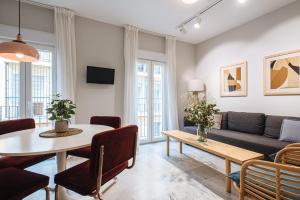 塞维利亚Magno Apartments Guadalquivir Terrace的客厅配有桌子和沙发