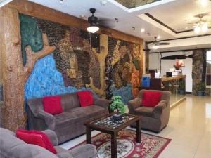 公主港OYO 880 Flores De Musa Inn的带沙发和大型壁画的客厅