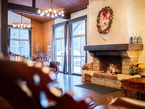 嬬恋村HOLIDAY VILLA Hotel & Resort KARUIZAWA的客厅设有壁炉和Christmas花圈