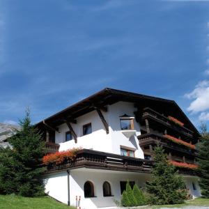 圣安东阿尔贝格Quality Hosts Arlberg - AFOCH FEI - das Landhaus的一座白色的大建筑,阳台上种有鲜花