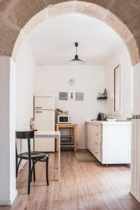 莫诺波利Casa Greta的厨房配有桌子和白色冰箱。