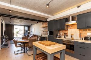 开普敦Docklands Luxury Two Bedroom Apartments的厨房配有黑色橱柜、桌子和用餐室。