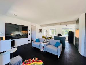 宾茨Haus Zudar / Prora的客厅配有2把椅子和平面电视