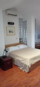 蒙卡列里Appartamento mansardato iPatrizi的卧室配有一张床和行李箱。