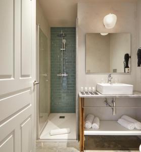 乌苏尔维尔Olivi1948 - Boutique Guest House的带淋浴、盥洗盆和镜子的浴室