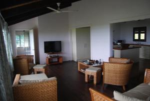 阿鲁坦加艾图塔基莫阿纳别墅的客厅配有藤椅和电视