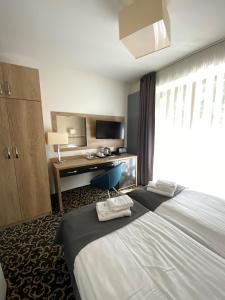 斯维诺乌伊希切Ośrodek Warszawianka的酒店客房设有一张大床和一张书桌。