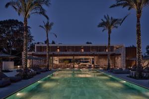 科斯镇Theros All Suite Hotel - Adults Only的一座别墅前方的棕榈树游泳池