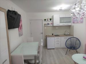 斯科普里City Lux Apartments的白色的小厨房配有桌子和椅子
