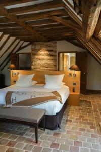 勒韦尔努瓦德乐伟诺酒店的一间卧室设有一张大床和砖墙