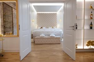 莱比锡布莱顿菲尔德城堡&塔古格酒店的卧室配有白色的床和镜子