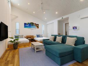 冲绳岛市la ohana～瀬底島～（2022年OPEN）的客厅配有蓝色的沙发和床。