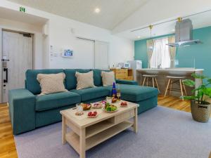冲绳岛市la ohana～瀬底島～（2022年OPEN）的客厅配有蓝色的沙发和桌子