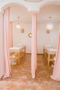 马拉喀什Le Pavillon de la Kasbah & SPA Marrakech的一间设有粉红色窗帘和桌子的客房