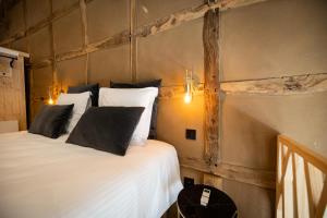 斯图蒙Paddock Lodge - Suites Wellness & Chambres d'hôtes的一间卧室配有带白色床单和黑色枕头的床。