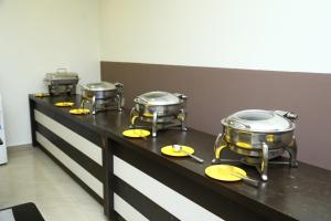 马杜赖Rio Grande Residency的桌子上一排黄色的锅碗瓢盆