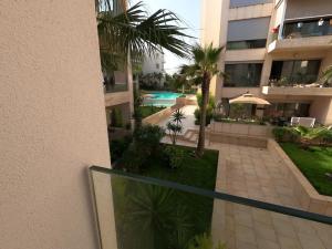 曼苏里亚Appartement Haut standing beach front à Mansouria, Mohammedia的公寓大楼设有游泳池和阳台