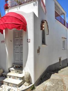 阿纳卡普里R&D Rest and Dream Capri的白色的建筑,有门和红伞