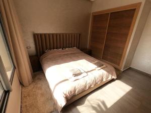 曼苏里亚Appartement Haut standing beach front à Mansouria, Mohammedia的一间卧室配有一张带木制床头板的床