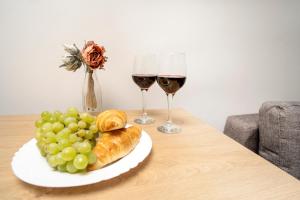 考纳斯House 22A Studio Apartments的一张桌子,上面放着两杯葡萄酒和一盘面包及葡萄
