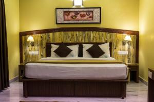 钦奈清奈之门酒店的一间卧室配有一张大床和木制床头板