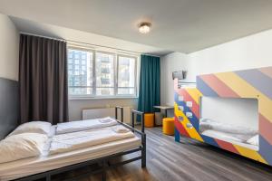 维也纳a&o维也纳中央火车站酒店的一间卧室设有一张床和色彩缤纷的墙壁
