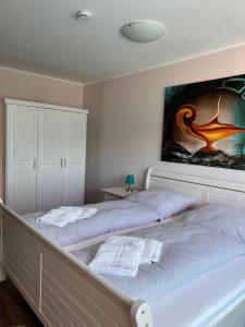 SchwabstedtKreatives Wohnen unter Reet ruhig und doch zentral的卧室内的两张床,墙上有绘画作品