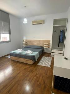 帕福斯Lovely studio apartment in Pafos的一间卧室配有一张床,铺有木地板