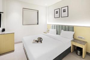 博帕尔FabHotel Oasis Yellow Courtyard的卧室配有白色床和显微镜