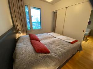 沃卡蒂Vuokatti Chalets Aarni的一间卧室配有一张带两个红色枕头的床