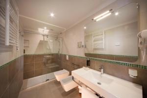 里米尼阿丽亚酒店的浴室配有盥洗盆、卫生间和浴缸。