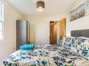 托基Lovely Stunning 2-Bed Cottage in Torquay的一间卧室配有一张带花卉床罩的床