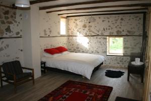 Hangjik (Little Inn)的一间卧室配有一张带红色枕头的床和一把椅子