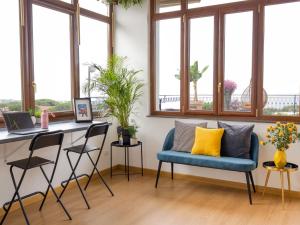 埃尔科拉诺Panorama Love to Stay的客房设有蓝色椅子、书桌和窗户。
