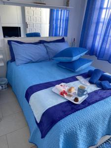 宏达海滩Casa Yurena的蓝色的床,上面有盘子的食物