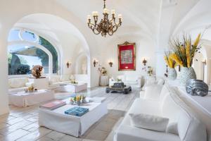 阿纳卡普里Jumeirah Capri Palace的客厅配有白色家具和吊灯。