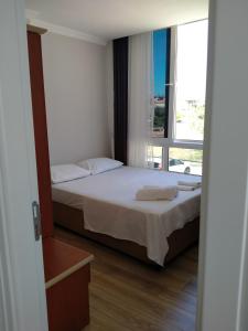 切什梅VENÜS PARK APART SUİTES的一间卧室设有一张床和一个大窗户